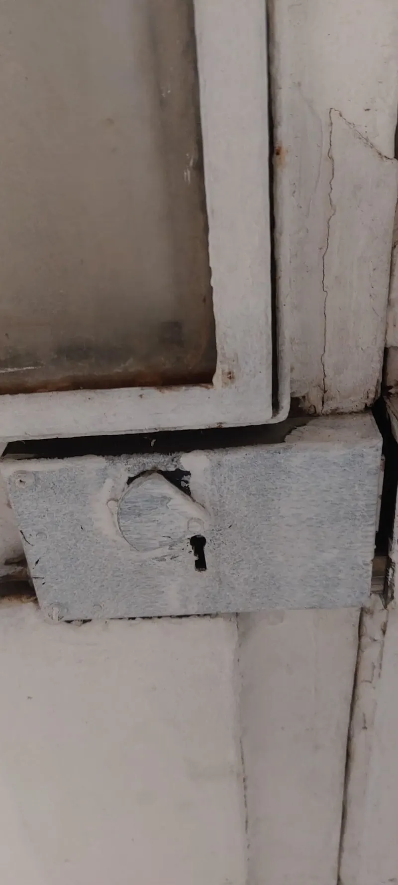 Ancienne serrure en applique sur un montant de porte, photo d'une intervention de France Serrures