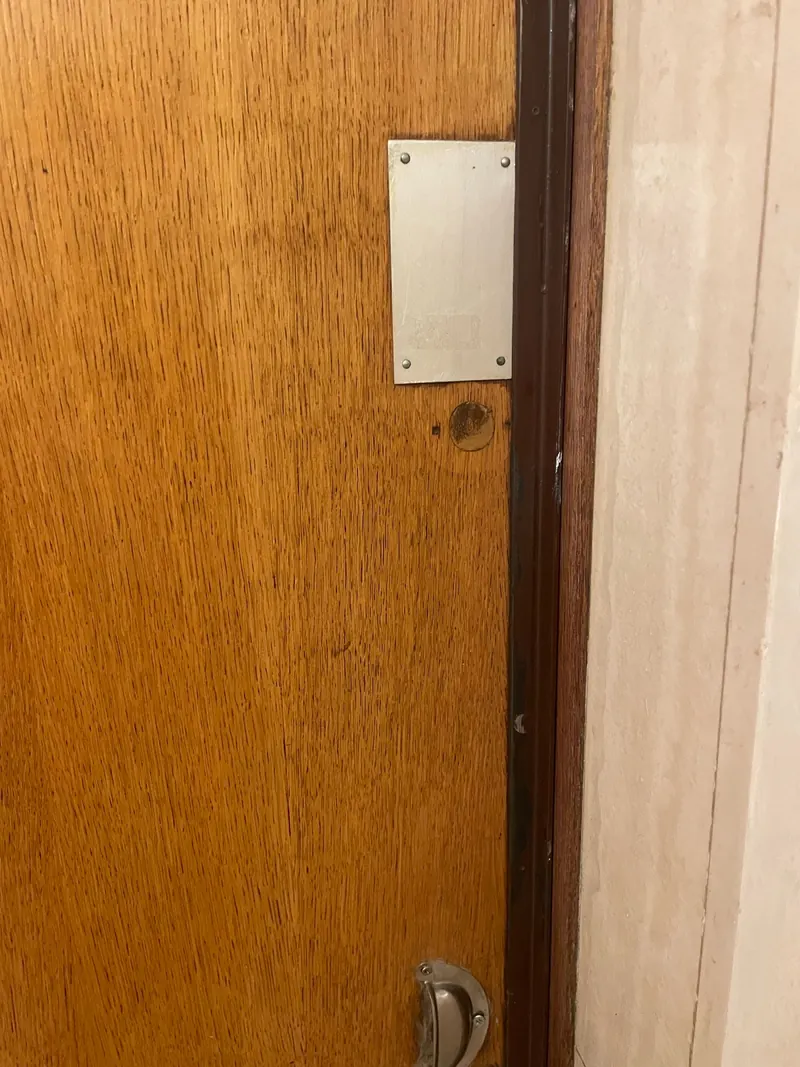 Porte en bois avec plaque de renfort au-dessus de la serrure, photo d'une intervention de France Serrures